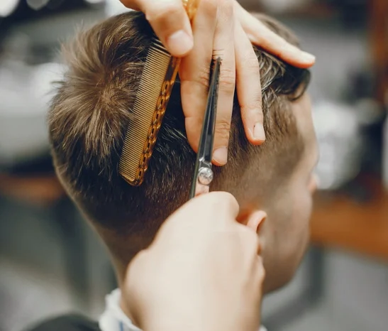 A man in a barbershop. A man cuts hair in a barbershop.