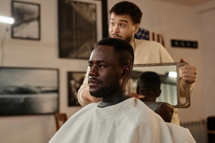 Customer admiring his haircut in barber shop