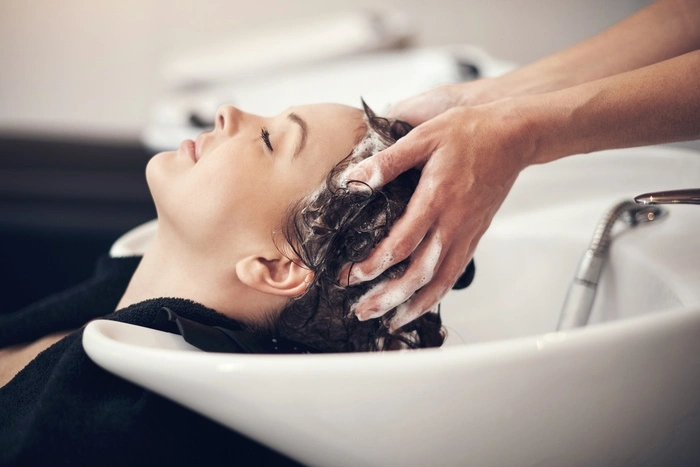 Hands, massage and hairdresser with client in spa