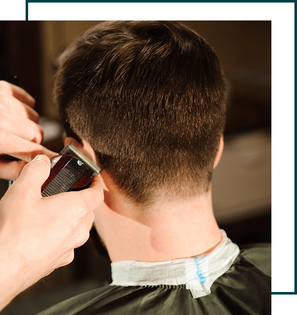 Master cuts hair and beard of men in the barbershop, hairdresser makes hairstyle for a young man